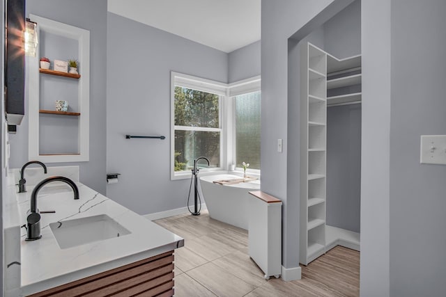21724 N Perry Rd, Colbert, WA 99005 - bathroom featuring a sink, a soaking tub, double vanity, and baseboards