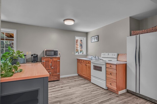 21724 N Perry Rd, Colbert, WA 99005 - kitchen with a sink, light wood-style flooring, white appliances, and baseboards