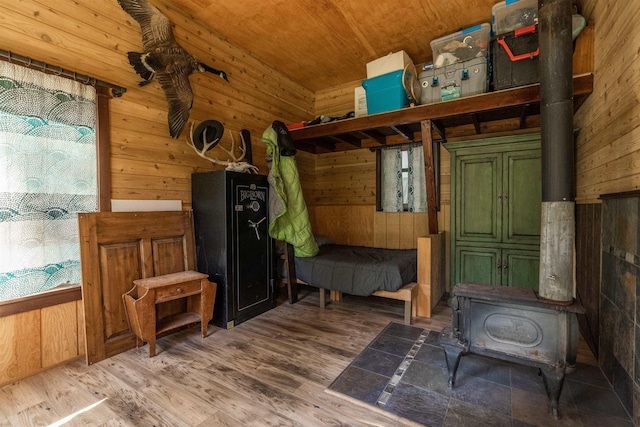 mudroom with a wood stove, wooden walls, wood ceiling, and wood finished floors