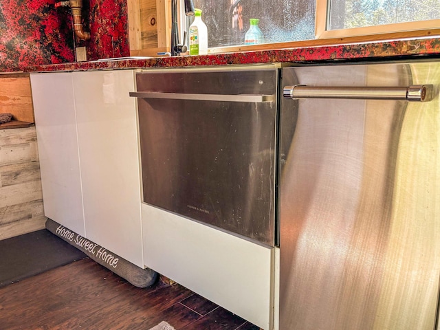 room details featuring a bar, dishwasher, and wood finished floors