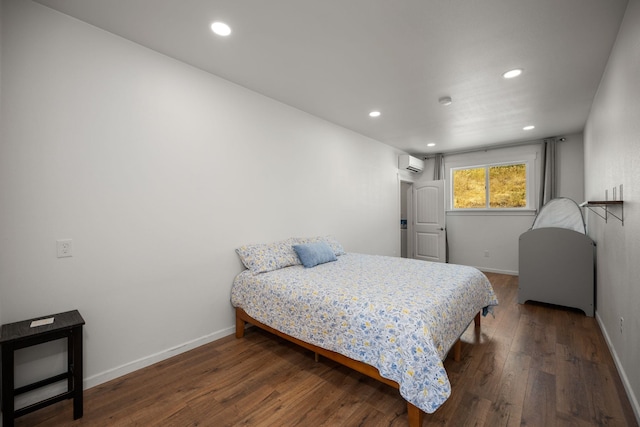 bedroom with a wall mounted air conditioner, baseboards, recessed lighting, and wood finished floors