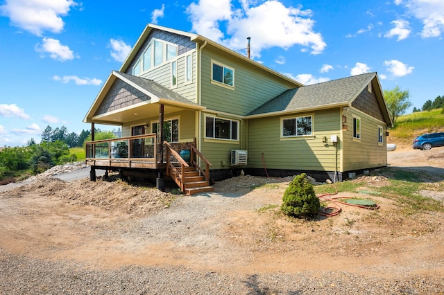 rear view of property featuring ac unit, a wooden deck, and a shingled roof