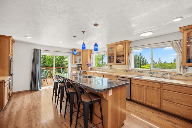 16717 E Washington Rd, Valleyford, WA 99036 - kitchen featuring stainless steel appliances, a sink, a breakfast bar, a center island with sink, and a textured ceiling