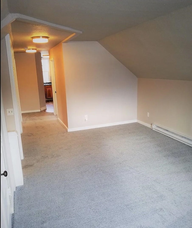 bonus room with lofted ceiling, baseboards, a baseboard heating unit, and carpet floors