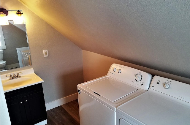laundry area with laundry area, washer and clothes dryer, dark wood-style floors, and a sink