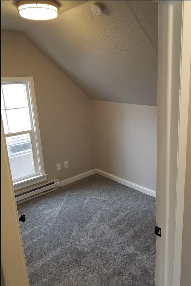 additional living space with vaulted ceiling, baseboards, a baseboard radiator, and dark colored carpet