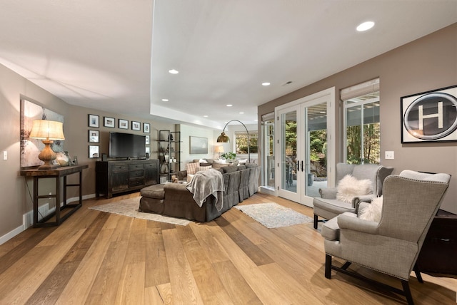 living area with light wood finished floors, french doors, baseboards, and recessed lighting