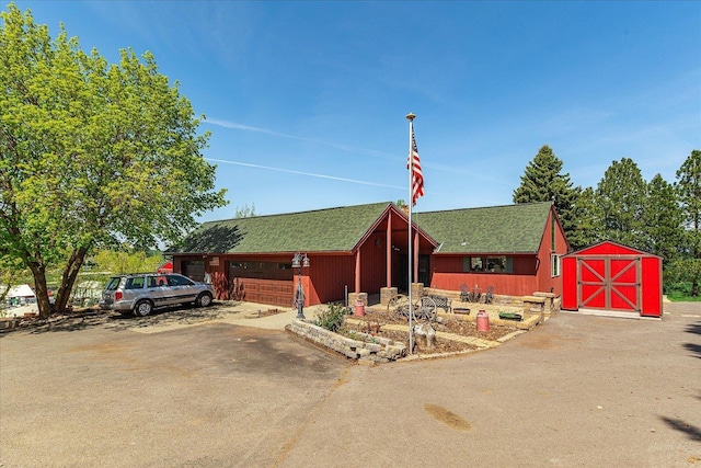406 N Northridge Way, Fairfield, WA 99012 - view of front of house featuring a storage unit, a garage, a shingled roof, and an outbuilding