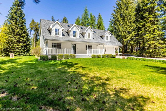 2712 W Eden Ln, Deer Park, WA 99006 - new england style home with covered porch, a shingled roof, an attached garage, and a front yard