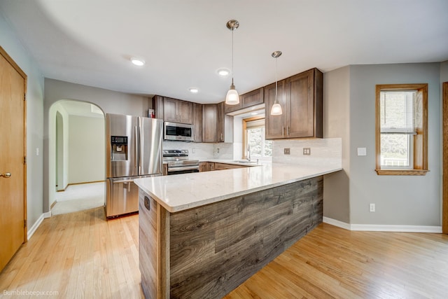 2712 W Eden Ln, Deer Park, WA 99006 - kitchen featuring a peninsula, light wood finished floors, a sink, stainless steel appliances, and baseboards
