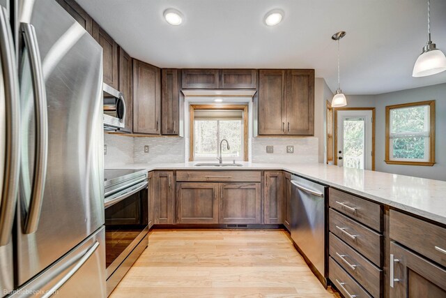 2712 W Eden Ln, Deer Park, WA 99006 - kitchen featuring light wood-type flooring, backsplash, appliances with stainless steel finishes, and a sink