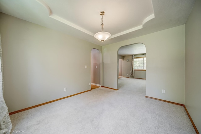 2712 W Eden Ln, Deer Park, WA 99006 - empty room with a tray ceiling, carpet, arched walkways, and baseboards