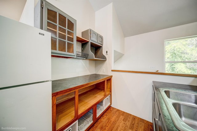 2712 W Eden Ln, Deer Park, WA 99006 - kitchen with freestanding refrigerator, lofted ceiling, light wood-style flooring, a sink, and dark countertops
