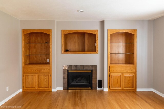 2712 W Eden Ln, Deer Park, WA 99006 - unfurnished living room with a tile fireplace, baseboards, visible vents, and wood finished floors