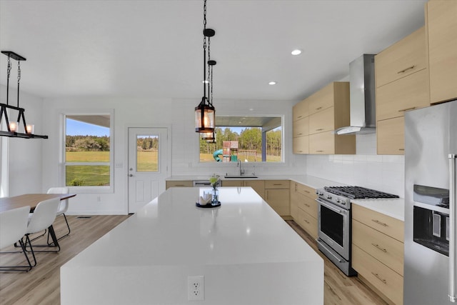 32715 N Elk Chattaroy Rd, Chattaroy, WA 99003 - kitchen featuring stainless steel appliances, wall chimney exhaust hood, light wood-style floors, light countertops, and plenty of natural light
