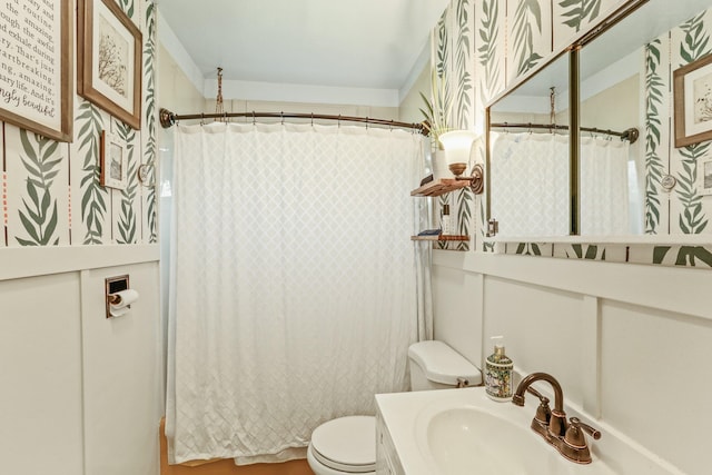 bathroom featuring toilet, vanity, and curtained shower