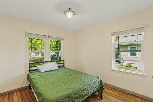 bedroom featuring wood finished floors and baseboards