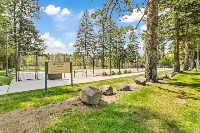 view of community featuring a yard, fence, and a gate