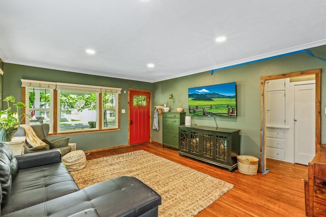 living room featuring wood finished floors, ornamental molding, and recessed lighting