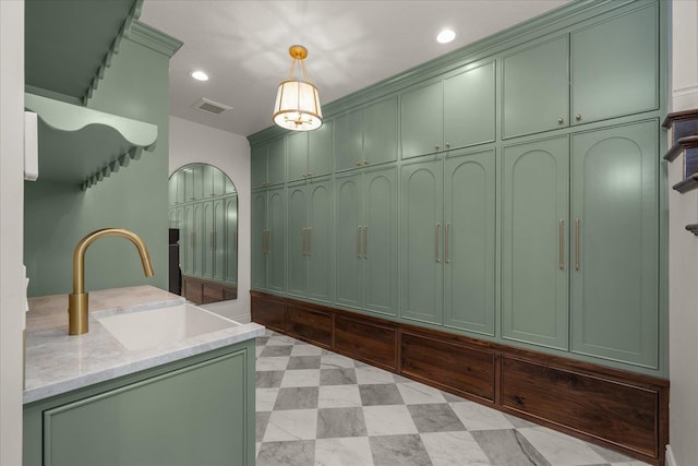 mudroom with a sink, arched walkways, and recessed lighting