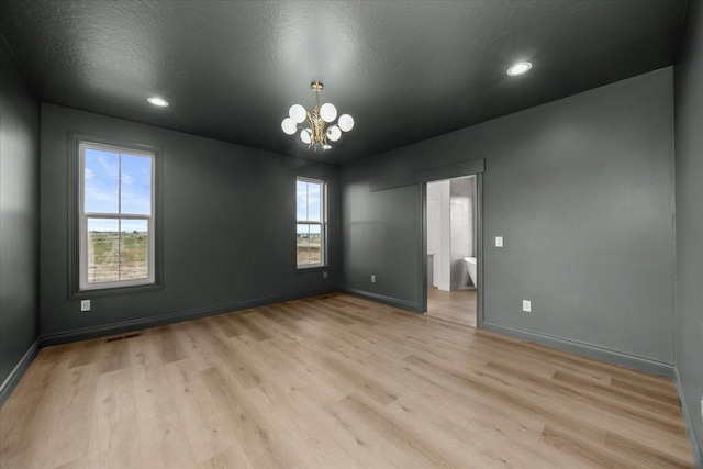 unfurnished room with a chandelier, light wood-style flooring, baseboards, and recessed lighting