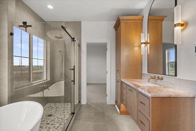 full bathroom with a stall shower, a freestanding tub, vanity, recessed lighting, and baseboards