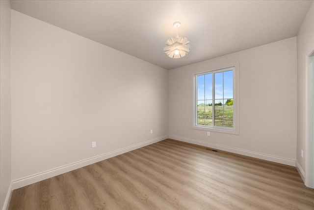 empty room featuring light wood finished floors and baseboards