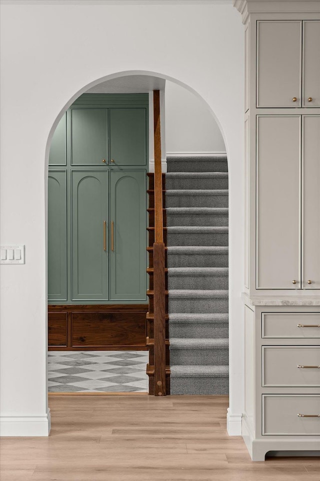 interior space featuring wood finished floors, arched walkways, and baseboards