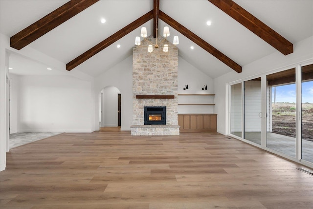 unfurnished living room with a chandelier, high vaulted ceiling, beam ceiling, arched walkways, and light wood-style flooring