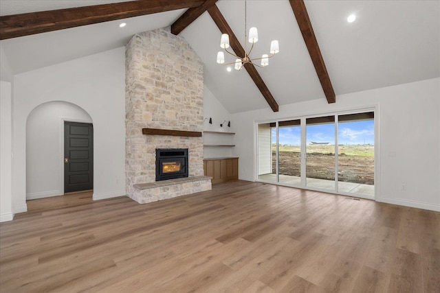 unfurnished living room with high vaulted ceiling, a chandelier, beamed ceiling, baseboards, and a fireplace