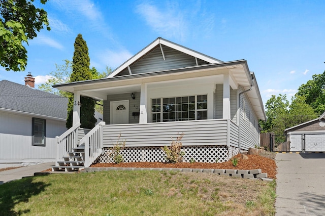 bungalow featuring a front lawn, a porch, and a gate
