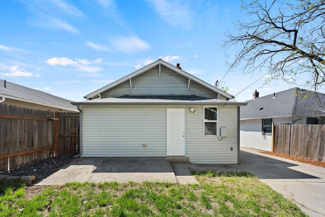 rear view of house with a patio and fence