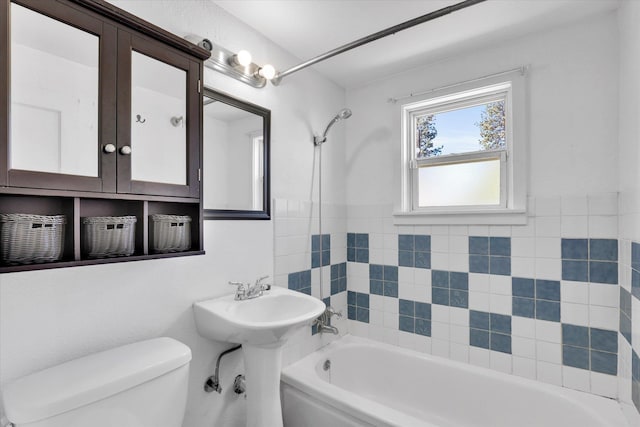 bathroom with toilet, washtub / shower combination, and a sink