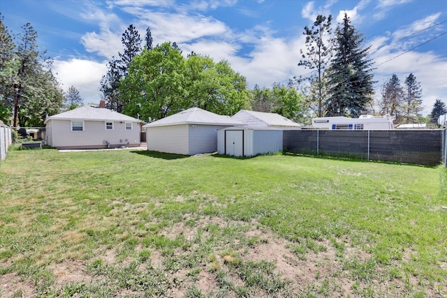 view of yard with an outbuilding, a shed, and a fenced backyard