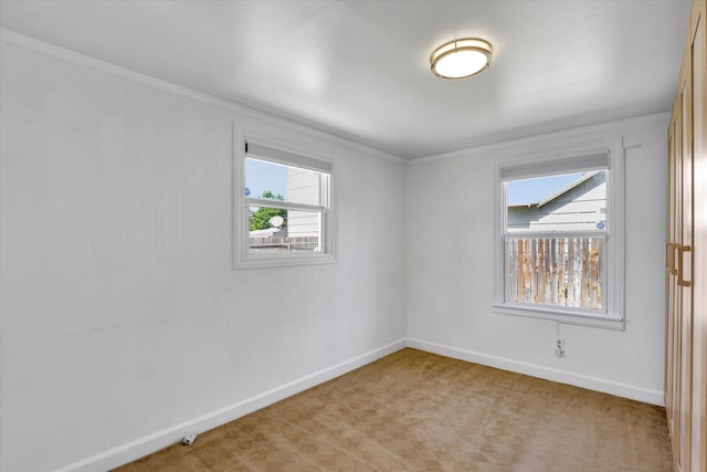 unfurnished room featuring light colored carpet, ornamental molding, and baseboards