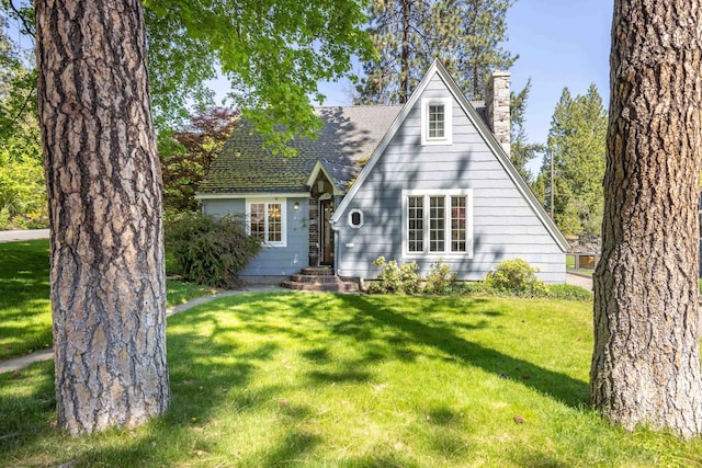 view of front of home with a chimney and a front yard