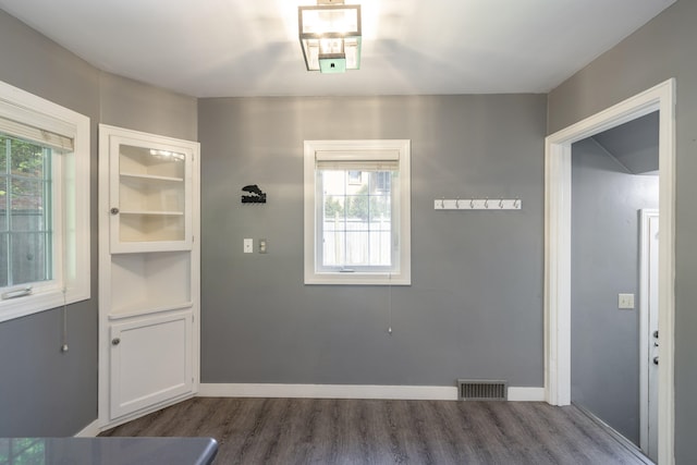 doorway to outside with dark wood finished floors, visible vents, and baseboards