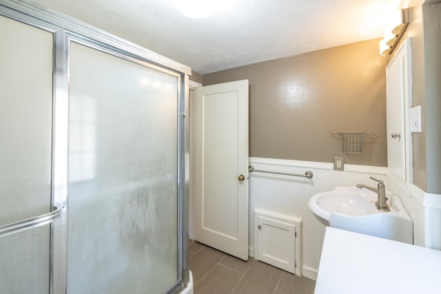full bath with vanity, wainscoting, and a shower stall