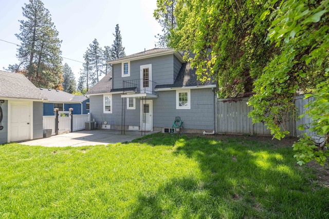 back of property with a patio area, fence, a lawn, central AC unit, and a shingled roof