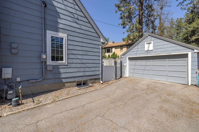 view of home's exterior featuring an outdoor structure, a garage, and fence