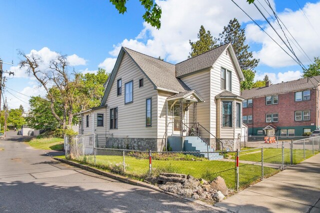 517 S Maple St, Spokane, WA 99204 - view of front of house with a front yard, a fenced front yard, and a shingled roof