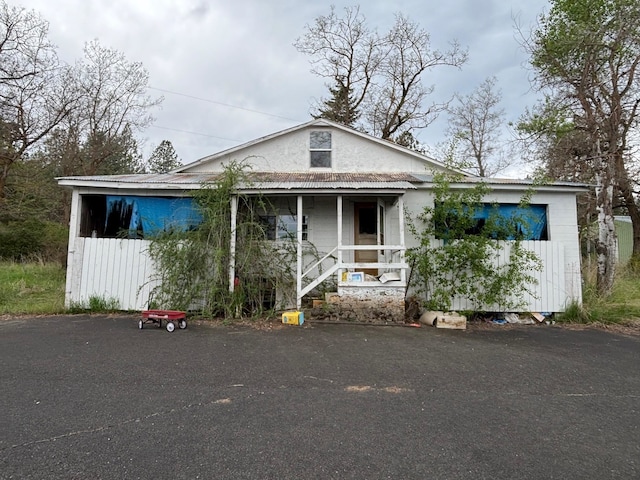 bungalow-style house with a porch and metal roof