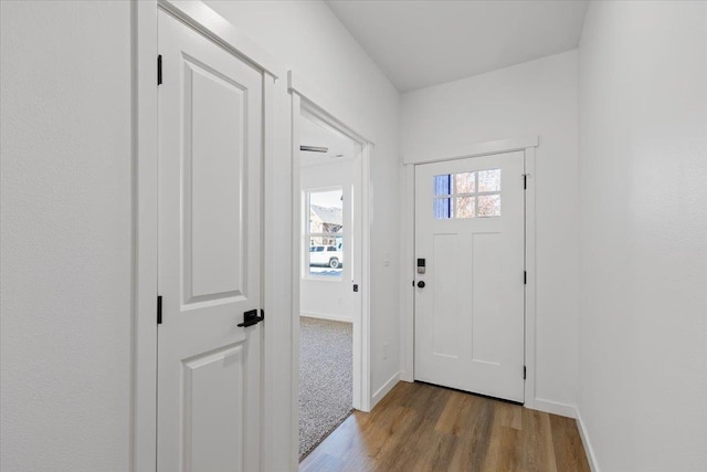 doorway featuring baseboards and wood finished floors