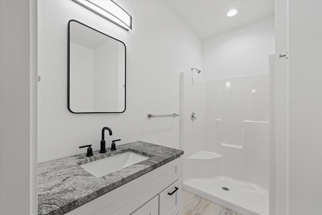 full bathroom featuring vanity, a shower stall, and wood finished floors