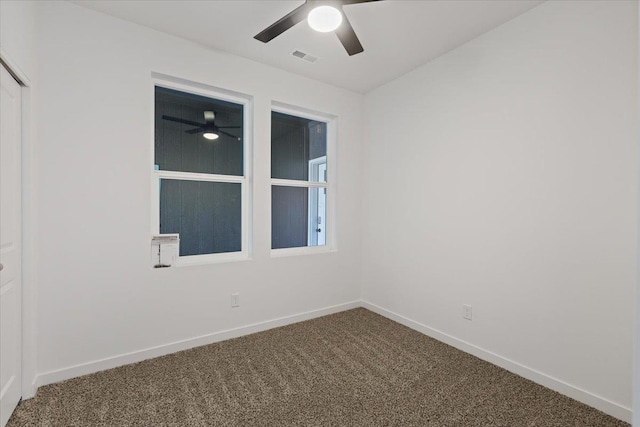 carpeted empty room with baseboards, visible vents, and ceiling fan