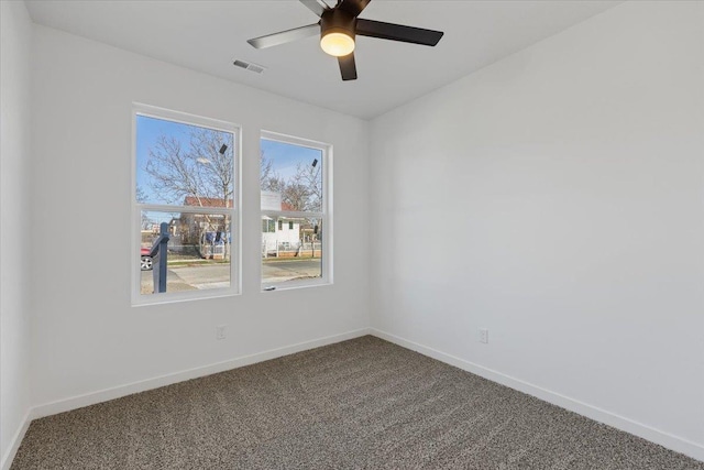 carpeted spare room with ceiling fan, baseboards, and visible vents