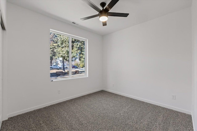 empty room with a ceiling fan, carpet flooring, visible vents, and baseboards