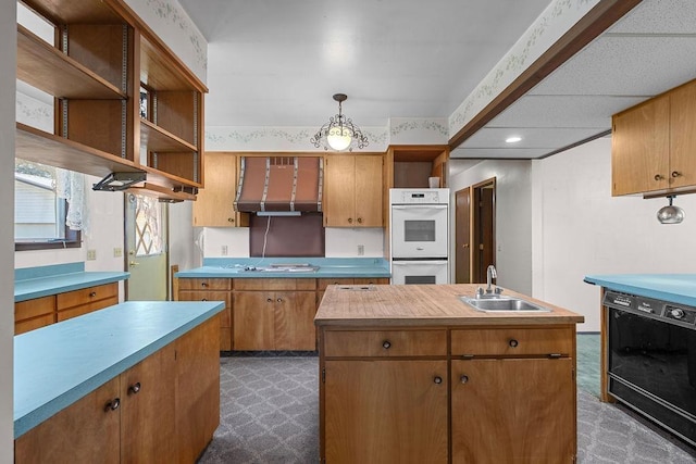 kitchen featuring exhaust hood, double oven, open shelves, and a sink