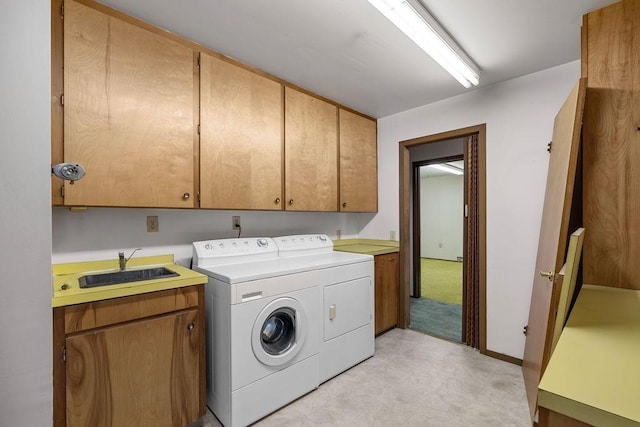clothes washing area with light floors, a sink, cabinet space, and washer and clothes dryer