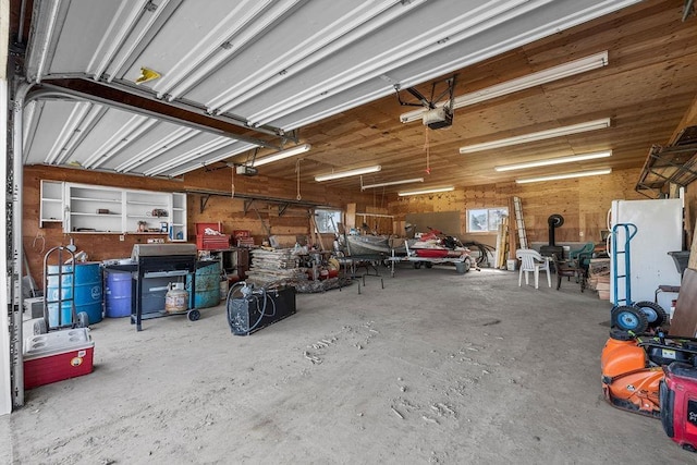 garage with freestanding refrigerator, a garage door opener, and a workshop area